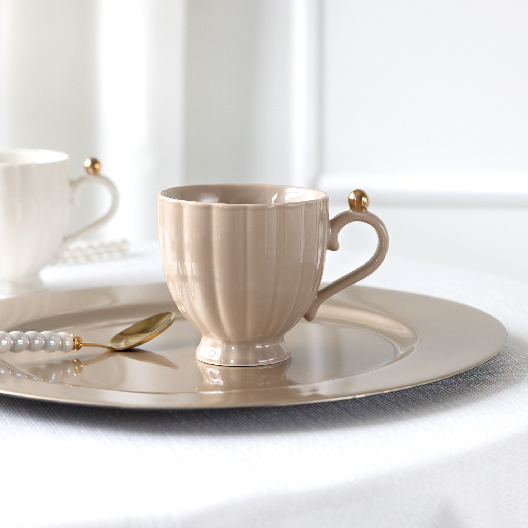 Béžová porcelánová šálka na stopke Curly Gold 250 ml AMBITION